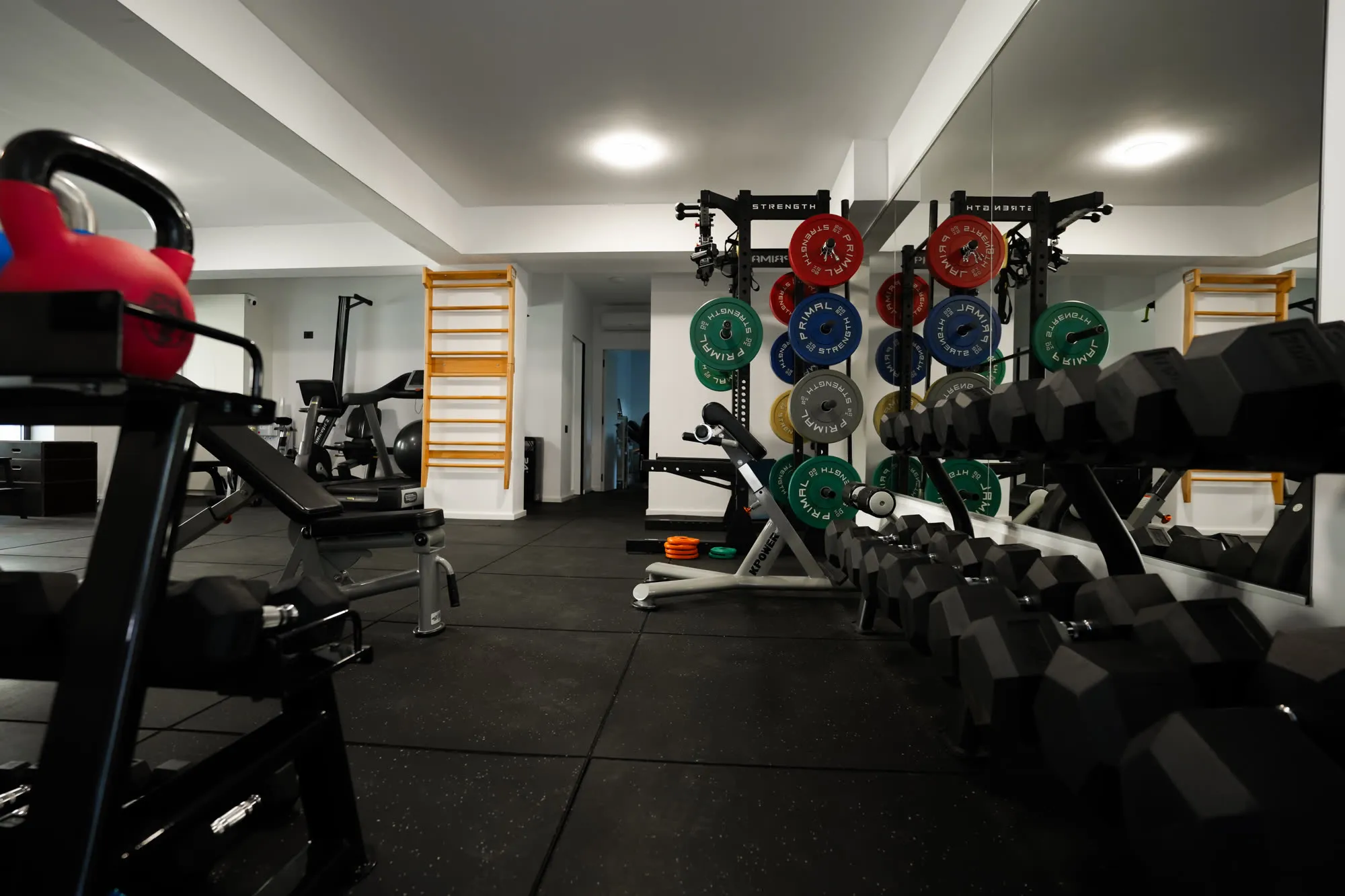Sala de forță FitSpace, cu rack-uri, discuri și zonă liberă de lucru